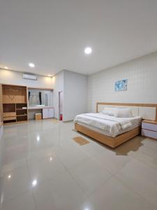 RatodenaLOSMEN 88的卧室配有床,铺有白色大瓷砖地板。