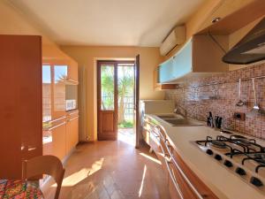 利莫内-苏尔加达Villa Fior di Loto的厨房配有水槽和炉灶 顶部烤箱