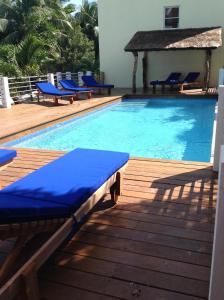 库尔克岛Caribbean Beach Suite的一个带蓝色躺椅和椅子的游泳池