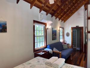 库尔克岛Sea Garden Cottage的一间卧室配有一张床和一张蓝色的沙发