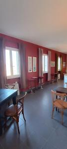 阿梅利亚Il Pescemagra HostelAmeglia的配有桌椅和红色墙壁的房间