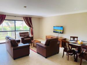 BijiloSeafront Residences & Hotel的客厅配有桌椅和电视。