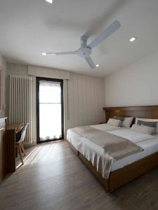加尔达湖滨阿尔伯格德瓦酒店 的一间卧室配有一张大床和吊扇