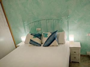 贝利雷瓜尔德Apartamento Gandia Bellreguard 3000的卧室内的一张带两个枕头的床