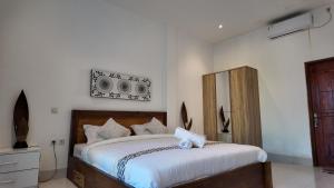 龙目岛库塔Turtle House Lombok的一间卧室配有一张带白色床单的大床