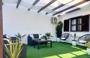 阿尔布费拉Feliz Algarve的绿草上带桌椅的庭院