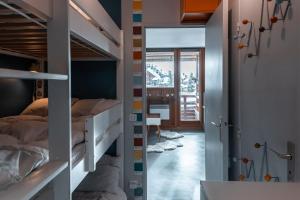 阿沃里亚兹IMMODREAMS - La Tanière - Avoriaz的一间带双层床的卧室和一个带书桌的走廊