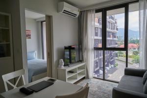 邦涛海滩Modern 2-bedroom Apartments. Skypark Laguna (Bang Tao)的客厅配有沙发和带电视的桌子