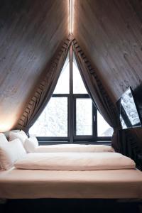 茵特斯托德TRIFORÊT alpinresort的一张位于带大窗户的房间内的床铺