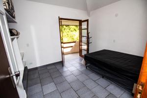 乌巴图巴Sobrado Dos Colibris 4 quartos的一间设有一张床的房间和一扇带窗户的门