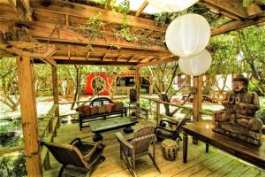 霍姆斯泰德Exotic Sukiya Tiny House Japanese Balinese Gardens的木制甲板配有桌椅和木制天花板