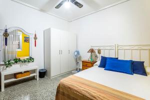 瓦伦西亚Precioso apartamento con terraza en Valencia的一间卧室配有一张带蓝色枕头的大床