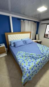 佛罗里达布兰卡Hospedaje Balcones de la Colina的一间卧室配有一张蓝色墙壁的床