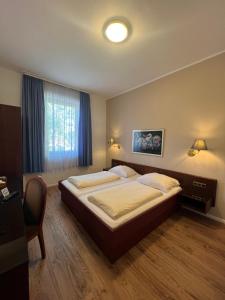 沃尔姆斯中心酒店的一间卧室设有一张大床和一个窗户。