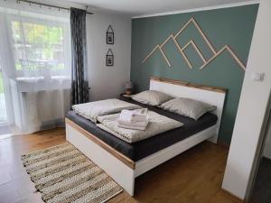 布伦纳Górski Zakątek Brenna的一间卧室配有一张黑白床架的床