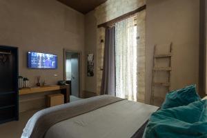 坎波巴索ArtStudio6 Dimora Artistica的一间卧室设有一张床、一台电视和一个窗口。