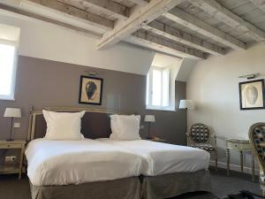 Sainte-SabineChâteau Sainte Sabine的卧室配有一张带白色床单和枕头的大床。