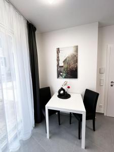 格拉茨Grazora Living Apartments的客房内的白色桌椅