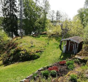 尼雪平House with lake plot and own jetty on Skansholmen outside Nykoping的山丘上带小房子的花园