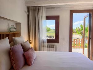 Pla del Panadés葡萄酒&烹饪派内迪斯住宿加早餐旅馆的卧室配有一张大白色床和窗户