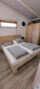 塞弗讷姆Casa 2234 op camping de Schatberg的配有两张大床的客房铺有木地板
