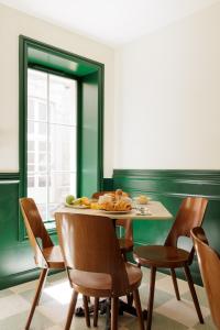 比亚里茨ALFRED HOTELS Port-Vieux - Ex Georges VI的一间拥有绿色墙壁和桌椅的用餐室