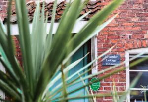 绍斯韦尔Southwell Holiday Cottage - Lavender Cottage的窗前有标志的砖砌建筑