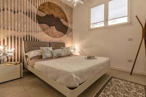 阿尔盖罗Luxury Sofia Home Alghero的一间卧室设有一张床和两个窗户。