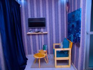 达喀尔达喀尔国际旅舍的一间设有紫色墙壁、电视和椅子的客房