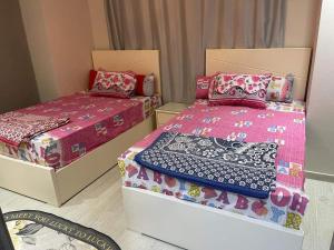艾因苏赫纳Ilmontegalala的小型客房 - 带两张床和粉红色