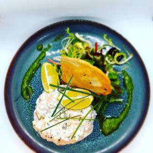 拉波勒Hôtel-Restaurant La Mascotte的蓝色的盘子,有鱼和蔬菜