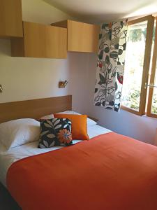 卢瓦尔河畔科讷库尔Chalet Loire proche Sancerre的一间卧室配有带橙色床单的床和窗户。
