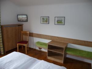 湖滨福煦Haus Lungau的一间卧室配有书桌、一张床和一把椅子