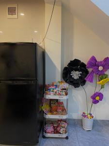 岑山Ngất Ngây Homestay的坐在食物架旁的黑色冰箱冰柜