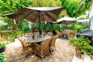 圣约翰斯Antigua Village Beach Resort的庭院配有桌椅和遮阳伞。