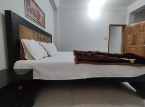 穆扎法拉巴德Marina Residency的一间卧室配有一张大床和木制床头板
