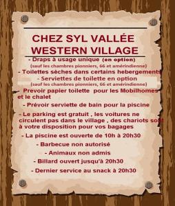 BouglonCamping Syl-Vallée Western Village的木墙上西卫斯利城村的标志