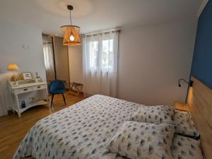 Gîte Oison, 2 pièces, 2 personnes - FR-1-590-428的一间卧室配有一张床、一张桌子和一盏灯