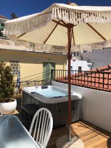 斯科派洛斯Evagelia's Villas的阳台的热水浴池和遮阳伞