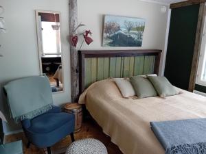 罗瓦涅米Experience accommadation Eco-Unela的一间卧室配有一张床和一张蓝色椅子
