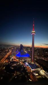 多伦多DOWNTOWN, LUXURY CONDO, CN TOWER, ROGERS CENTER, SCOCIA ARENA, UNOBSTRUCTED VIEW的电视塔在晚上可欣赏到城市美景