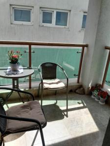 北马马亚-讷沃达里Ap Hector的阳台配有桌子和桌椅。