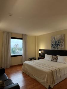 玛利亚镇公园酒店及套房的一间卧室设有一张大床和一个大窗户