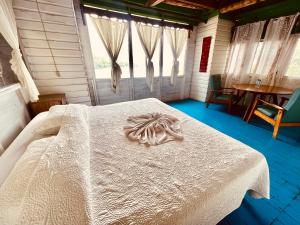里约杜尔塞HOTEL BACKPACKERS RIO DULCE的一间设有白色床的卧室,位于带窗户的房间内