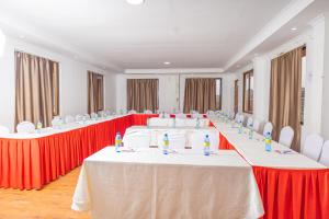 ThikaPaleo Hotel and Spa的红白椅子的房间的一排桌子