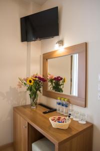 特尔斐THOLOS HOTEL的梳妆台、镜子、鲜花和水瓶