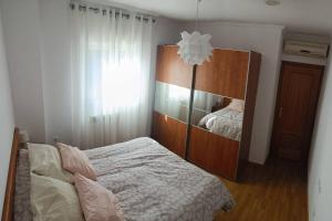 阿尔卡拉拉雷亚尔Apartamento con terraza 2 hab.的一间卧室配有一张床和一个木制橱柜