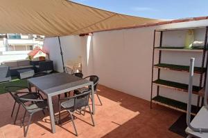 阿尔卡拉拉雷亚尔Apartamento con terraza 2 hab.的一个带桌椅的庭院和一个帐篷