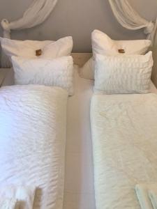 沙博伊茨Ostseeferien bei Bella Wohnung EG的床上的两堆白色枕头