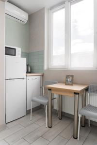 哈尔科夫Бірюзова студія, Південний вокзал 5 хвилин的厨房配有桌椅和冰箱。